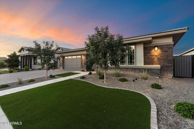 view of front of property with a garage and a lawn