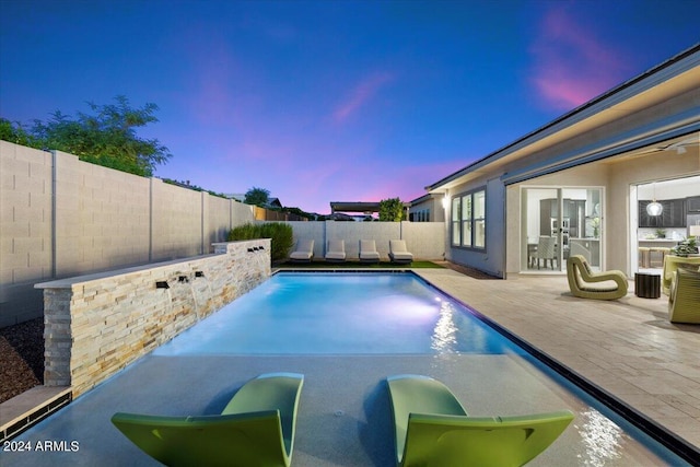 pool at dusk with a patio