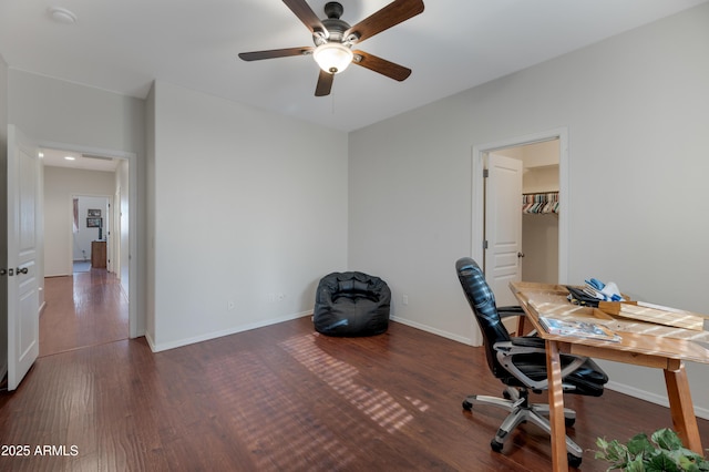 unfurnished office with wood finished floors, a ceiling fan, and baseboards