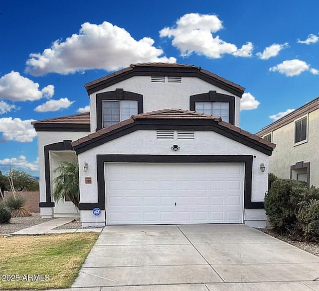 view of front of house with driveway, an attached garage, a tiled roof, and stucco siding