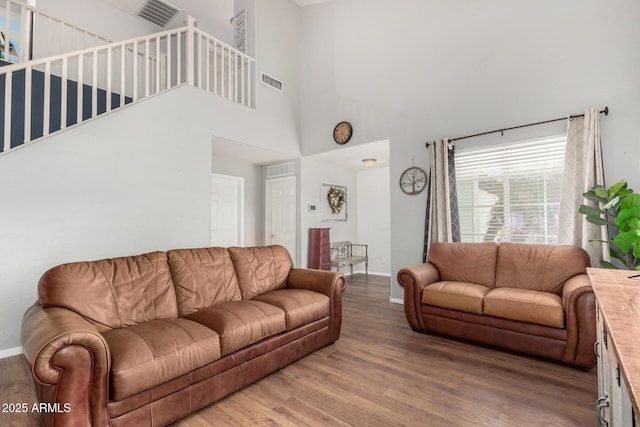 living room with wood finished floors, baseboards, and visible vents