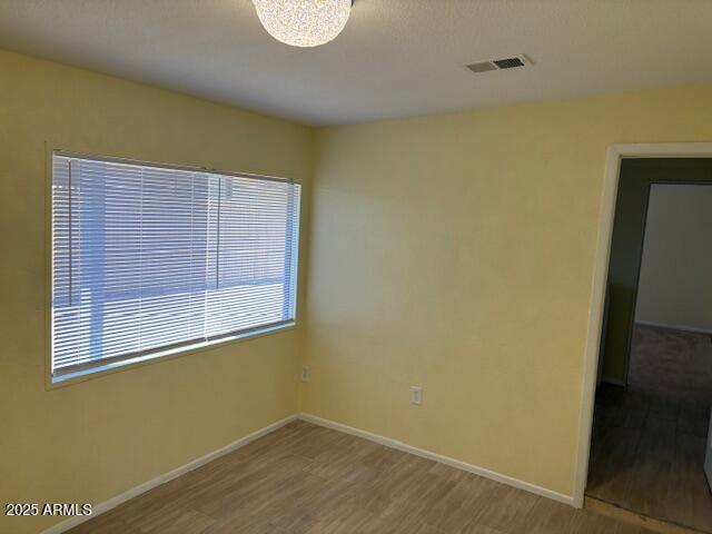spare room with wood finished floors and baseboards