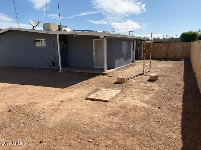back of house featuring a fenced backyard and stucco siding