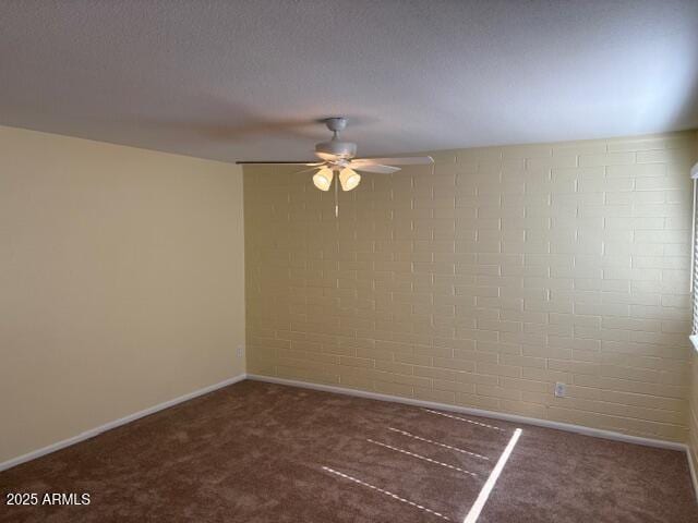 carpeted spare room featuring ceiling fan and baseboards