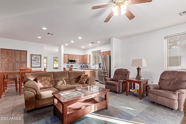 living room featuring a ceiling fan, recessed lighting, visible vents, and light tile patterned floors