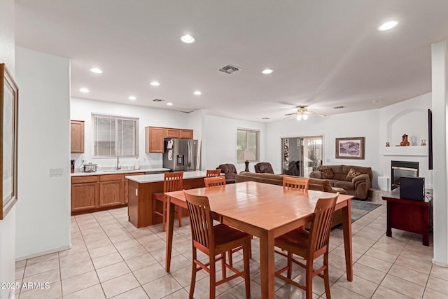 dining area featuring light tile patterned floors, recessed lighting, visible vents, a glass covered fireplace, and ceiling fan