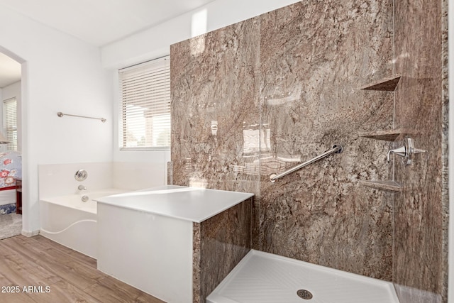 bathroom featuring a garden tub, wood finished floors, and a tile shower