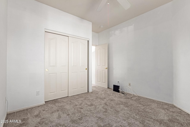 unfurnished bedroom featuring carpet floors, a closet, and a ceiling fan