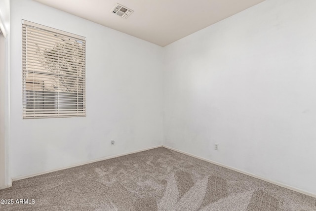 carpeted spare room with visible vents and baseboards