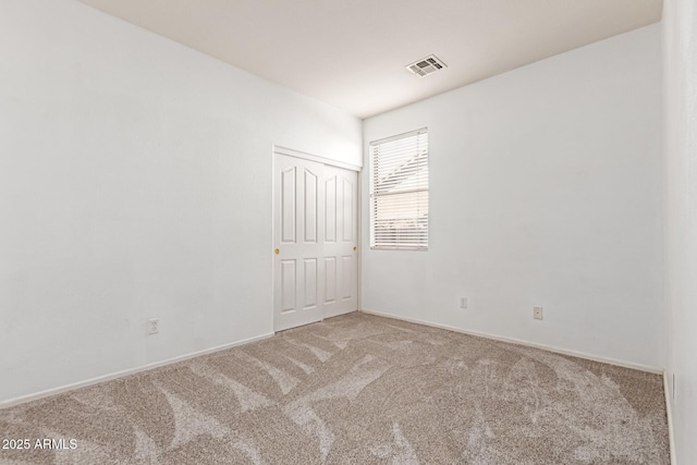 unfurnished room with baseboards, visible vents, and carpet flooring