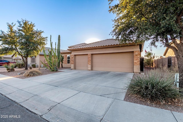 view of front of property featuring a garage, concrete driveway, a tile roof, and stucco siding