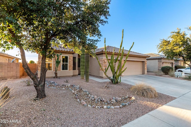 view of front facade with an attached garage, fence, a tile roof, concrete driveway, and stucco siding