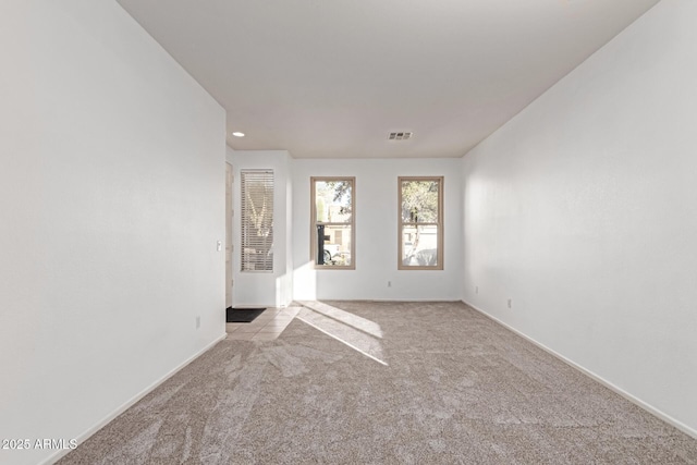 unfurnished room with visible vents and carpet flooring