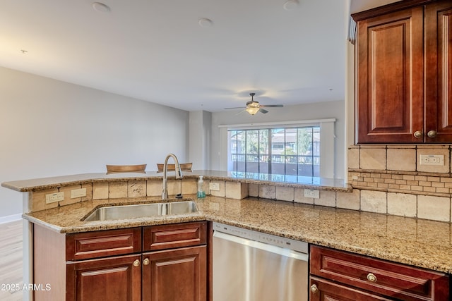 kitchen featuring ceiling fan, dishwasher, light stone countertops, sink, and kitchen peninsula