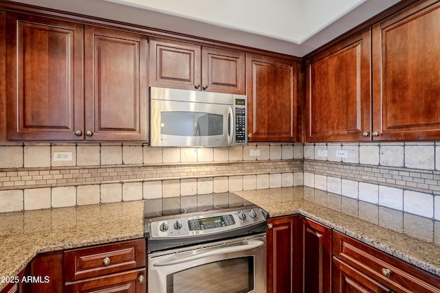 kitchen featuring decorative backsplash, light stone counters, and stainless steel appliances