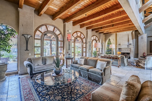 living room with a large fireplace, beamed ceiling, and wooden ceiling