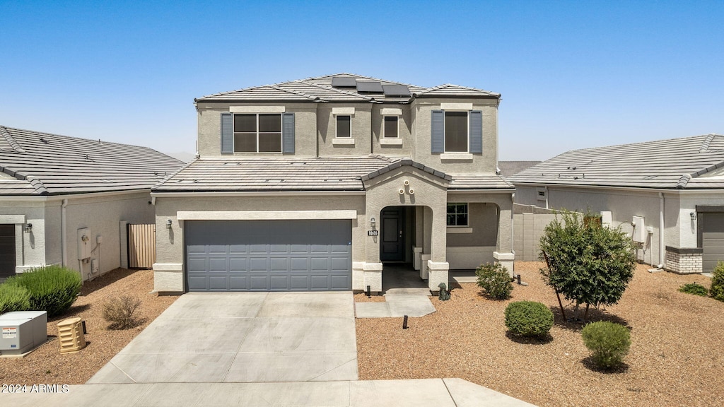 view of front of home featuring a garage and solar panels