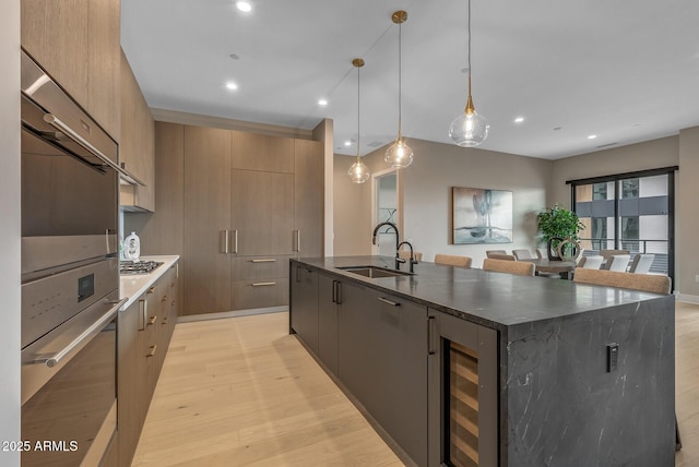 kitchen with a spacious island, recessed lighting, light wood-style floors, modern cabinets, and a sink