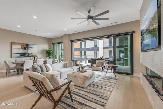 living room featuring recessed lighting, light wood-style flooring, baseboards, and a ceiling fan