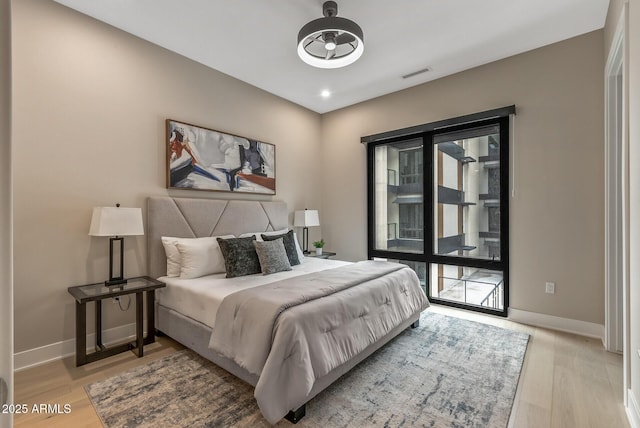 bedroom with visible vents, baseboards, and wood finished floors