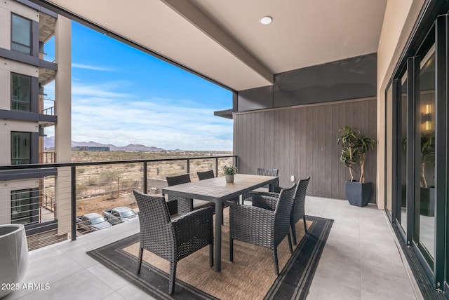 balcony with outdoor dining area and a mountain view