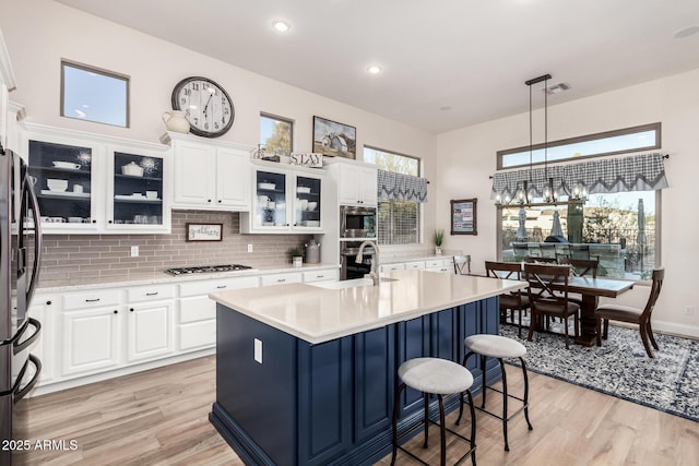 kitchen with light wood-type flooring, light countertops, a sink, and stainless steel appliances