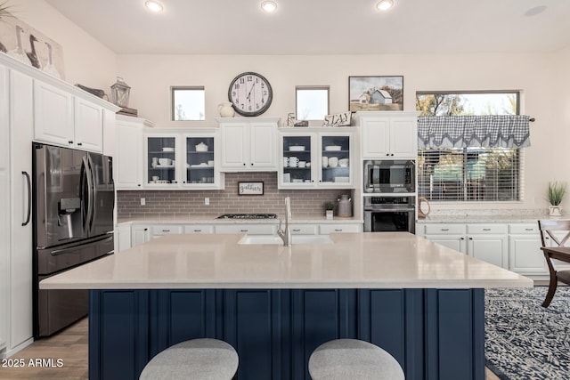 kitchen featuring light countertops, appliances with stainless steel finishes, a sink, and a breakfast bar area