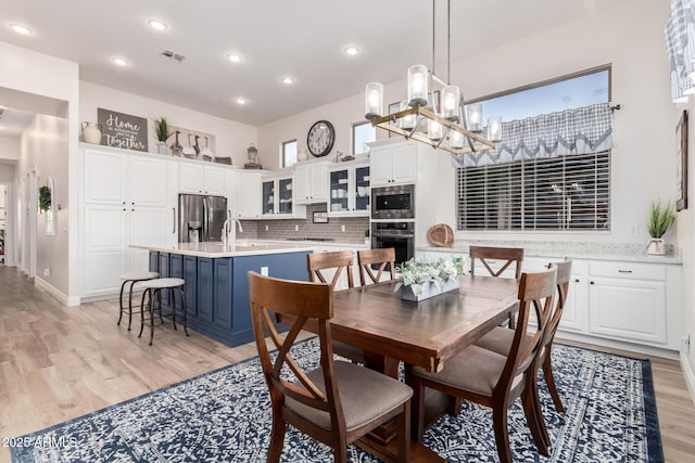 dining space featuring visible vents, baseboards, a notable chandelier, light wood-style floors, and recessed lighting
