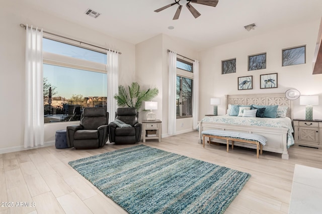 bedroom with visible vents, baseboards, and wood finished floors
