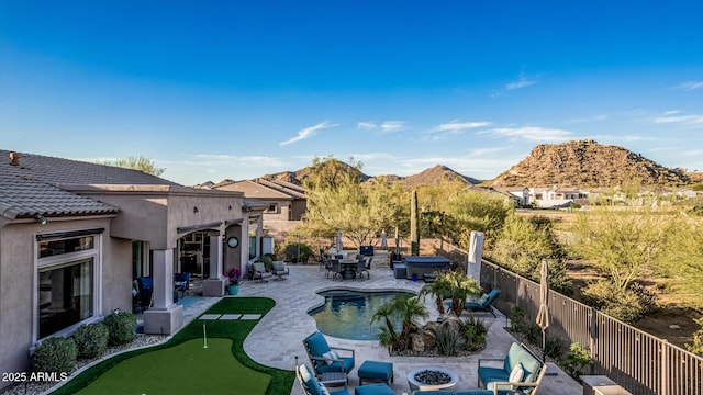 view of swimming pool with a fenced in pool, a mountain view, a fire pit, and a patio area