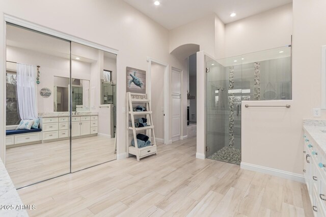 full bathroom featuring a stall shower, baseboards, recessed lighting, and vanity