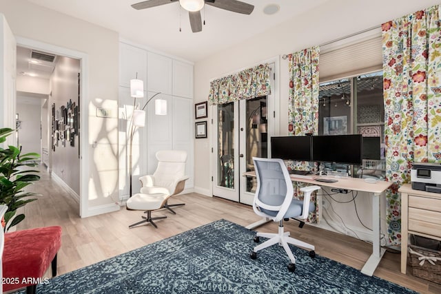 office featuring visible vents, a ceiling fan, light wood-style flooring, and baseboards