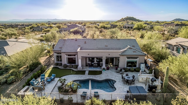 rear view of house featuring a fenced backyard, stucco siding, a patio area, and a tile roof