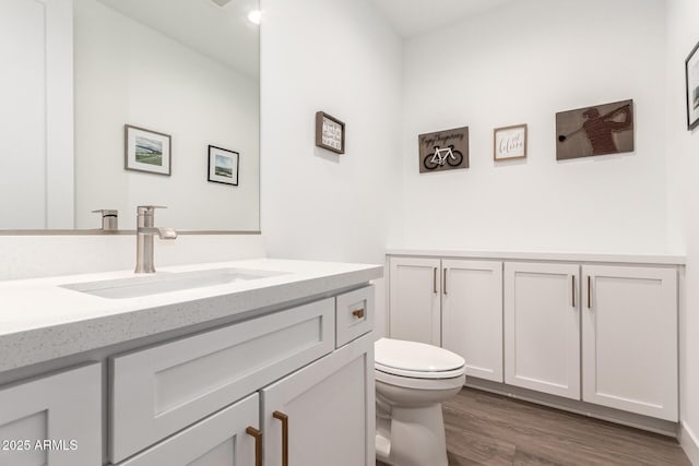 bathroom featuring hardwood / wood-style flooring, vanity, and toilet