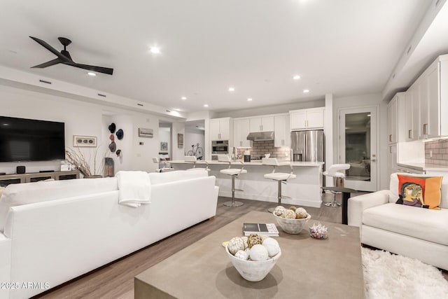 living room featuring ceiling fan and light hardwood / wood-style flooring