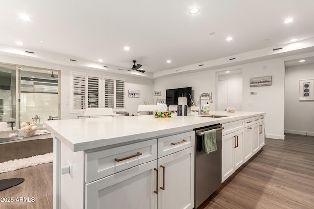 kitchen with sink, white cabinetry, a center island, stainless steel dishwasher, and dark hardwood / wood-style flooring