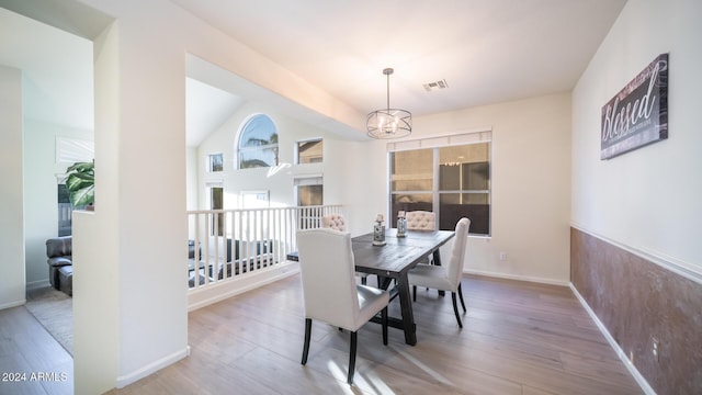 dining area featuring light hardwood / wood-style flooring and a notable chandelier