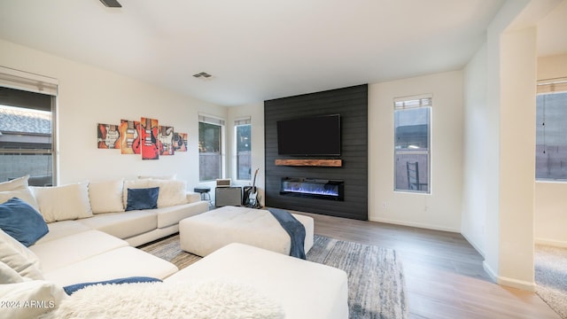 living room with a large fireplace and light hardwood / wood-style flooring