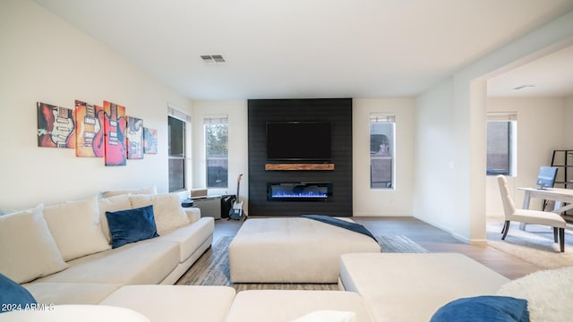 living room with hardwood / wood-style floors and a large fireplace