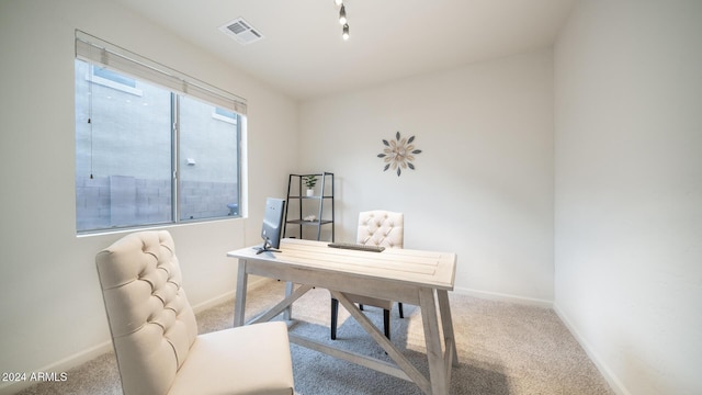 carpeted office featuring track lighting