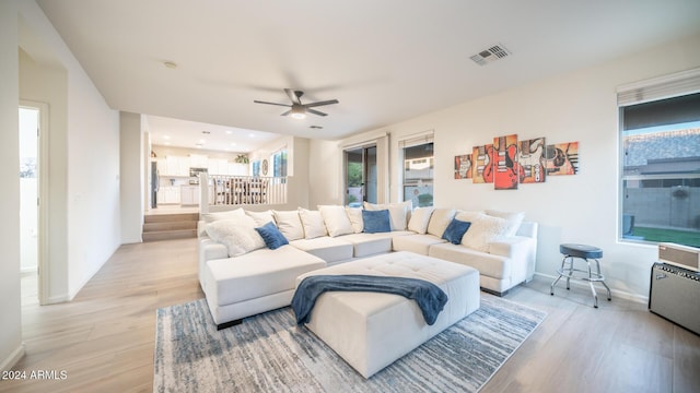 living room featuring light hardwood / wood-style flooring and ceiling fan