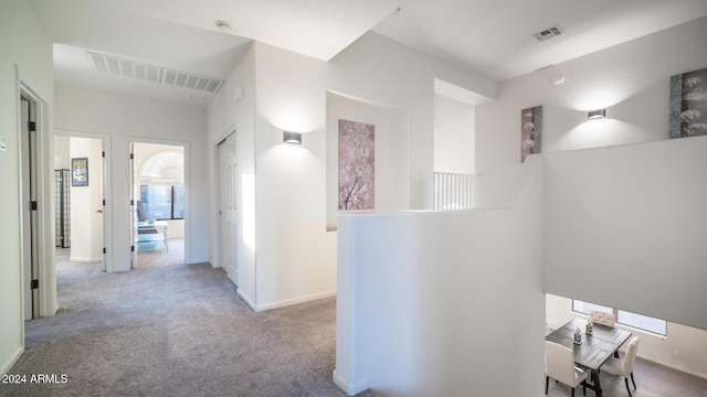 hallway with light colored carpet