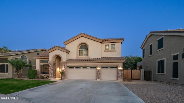 mediterranean / spanish home featuring a front yard and a garage