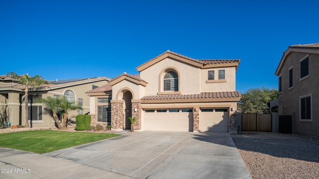 mediterranean / spanish-style home with a front lawn and a garage