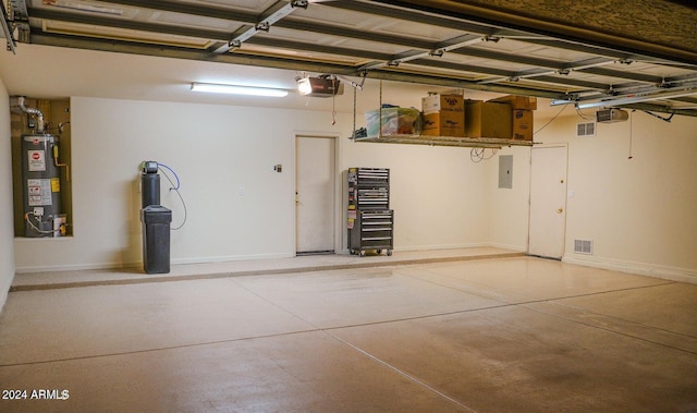 garage with electric panel, a garage door opener, and gas water heater