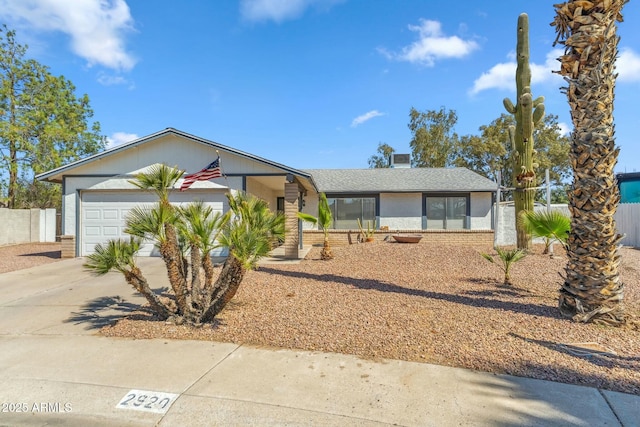 mid-century inspired home featuring brick siding, concrete driveway, a garage, and fence