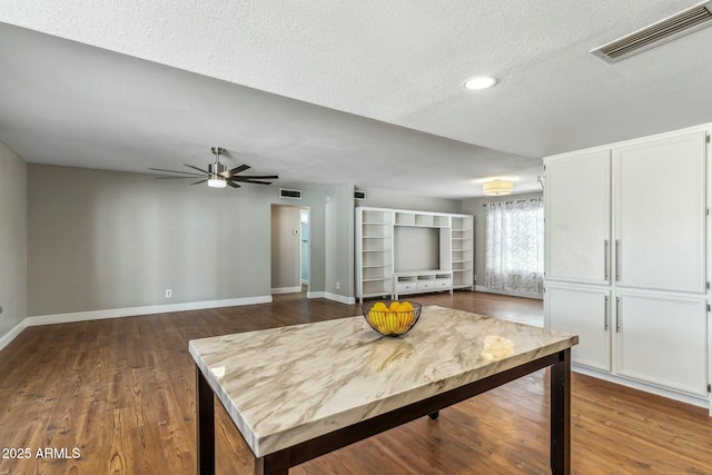 kitchen featuring visible vents, baseboards, and dark wood-style floors