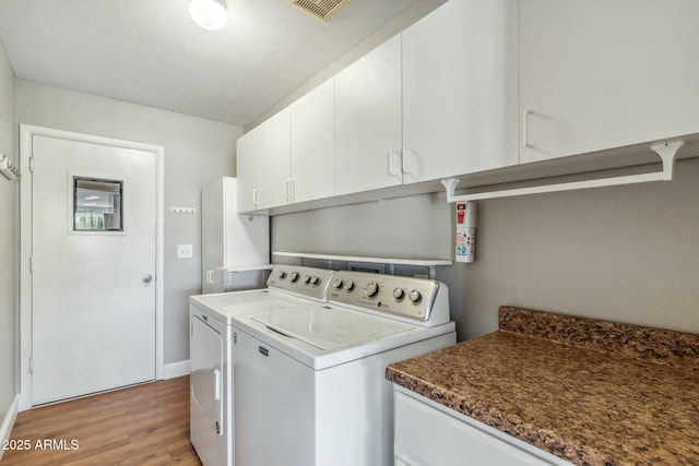 laundry room featuring visible vents, independent washer and dryer, light wood-style flooring, cabinet space, and baseboards