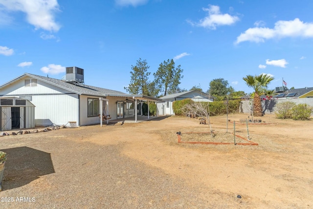 rear view of property with a patio, an outbuilding, central AC unit, and a storage shed