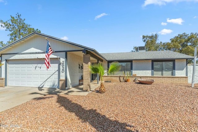 ranch-style house featuring driveway, brick siding, roof with shingles, and an attached garage